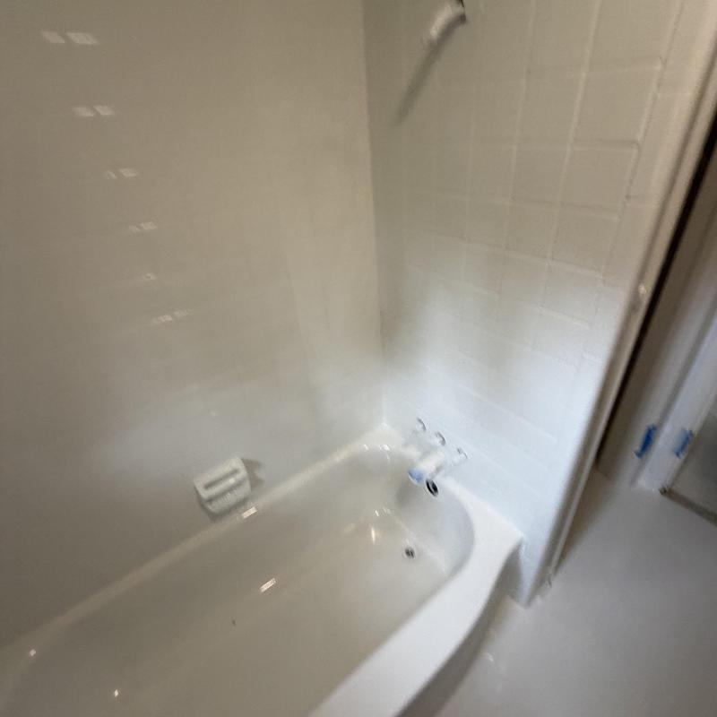Bathtub and tile refinishing in white bathroom