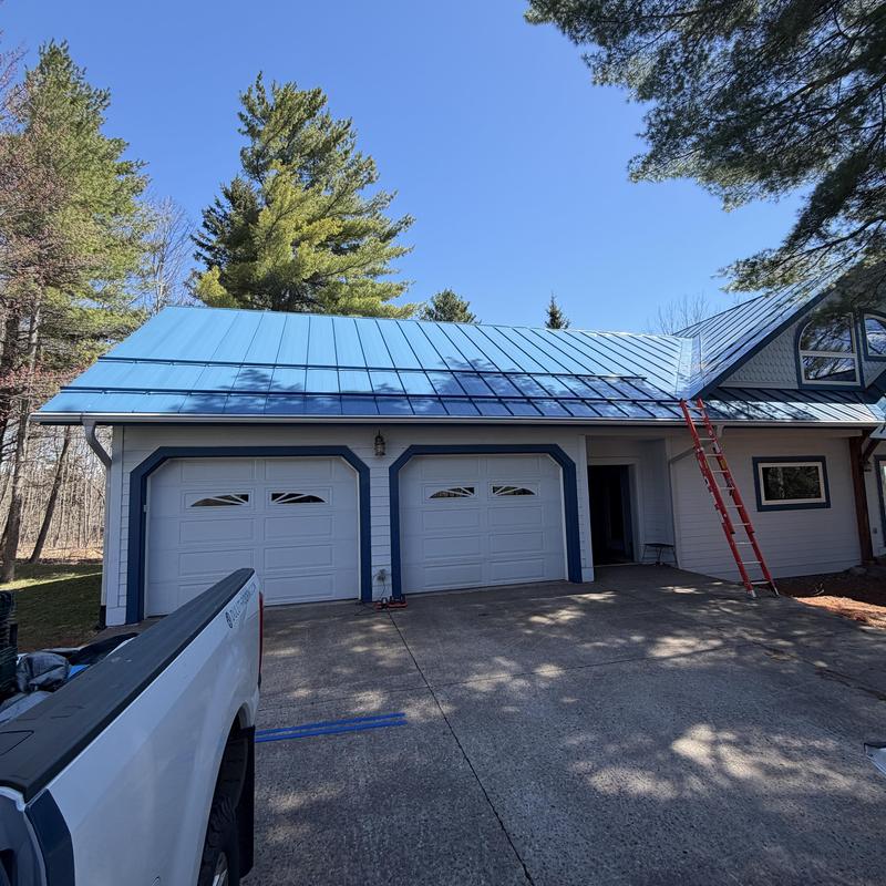 Clamp-to-seam snow bar system on blue steel roof
