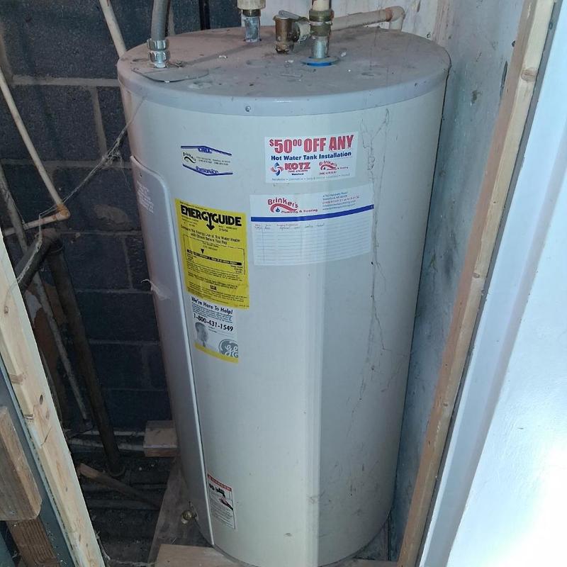 Water heater tank with plumbing connections and labels