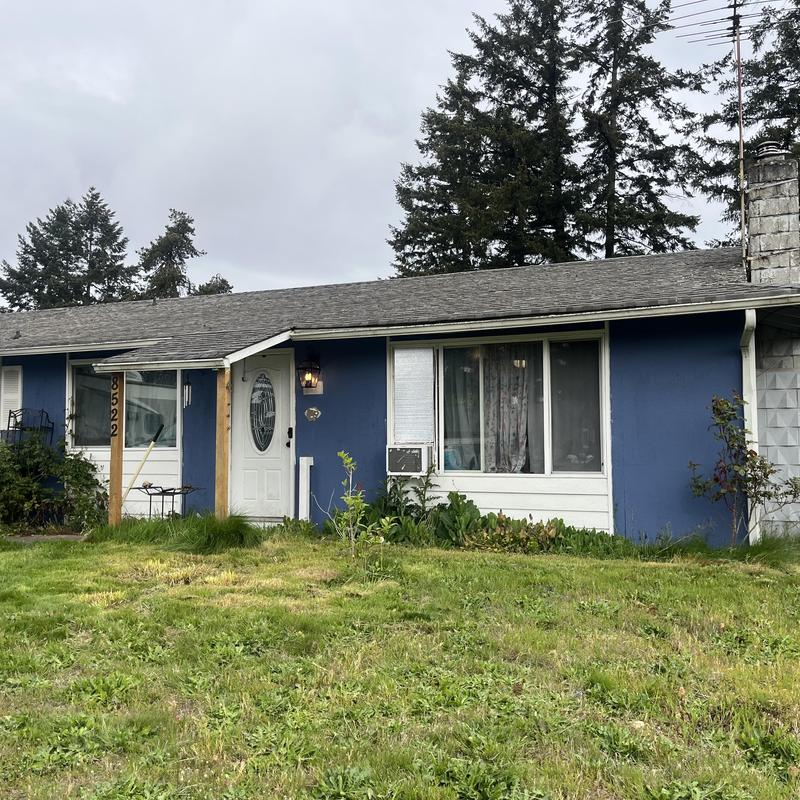 Asphalt shingle roof on blue house with front yard