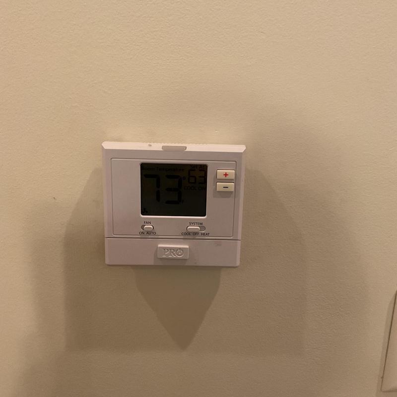 Thermostat display showing room temperature at 73°F