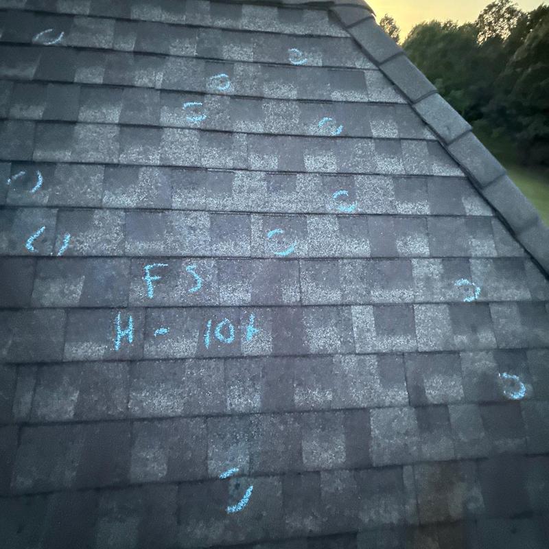 Asphalt roof shingles marked for hail damage inspection