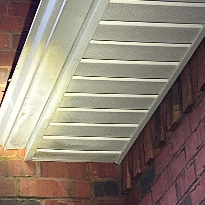 Soffit ventilation panels under roof eave on brick wall