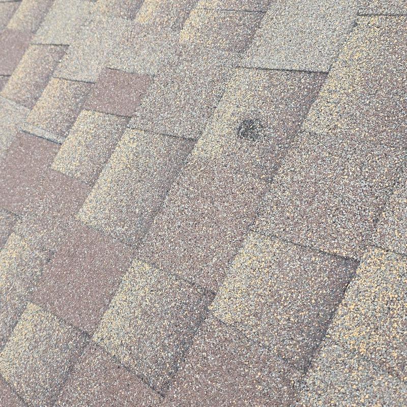 Asphalt shingle roof with hail impact damage close-up
