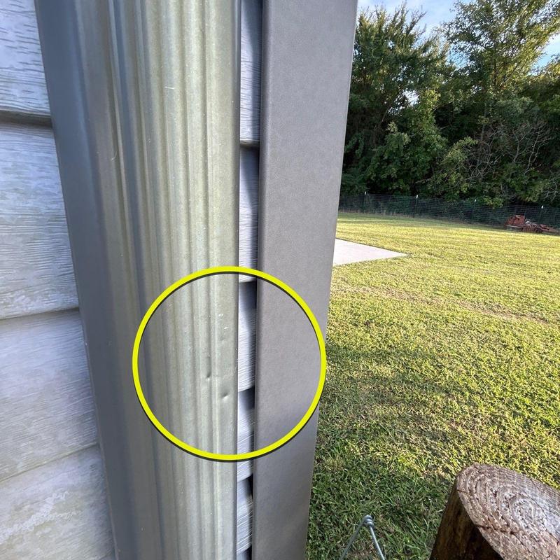 Metal siding dent with circled damage on exterior wall