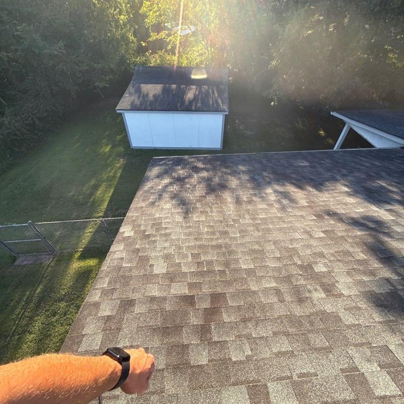 Asphalt shingle roof with hail damage inspection in sunlight