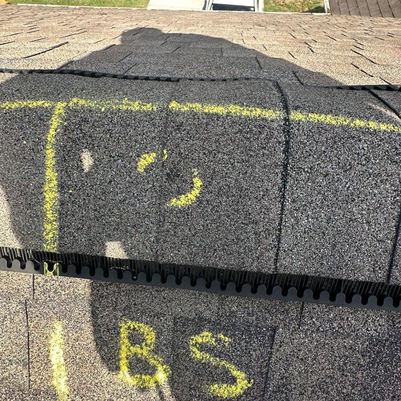 Roof shingles with yellow-marked hail damage signs