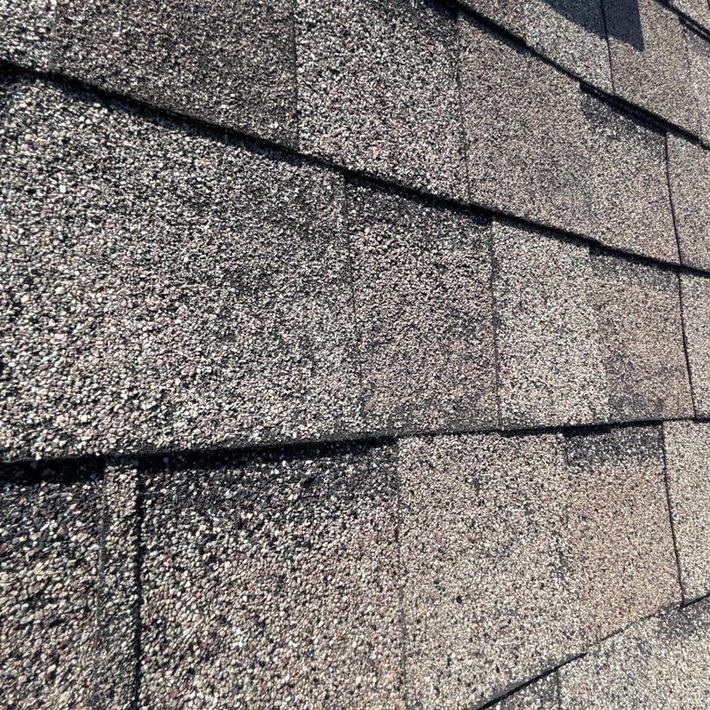 Asphalt shingles close-up showing hail damage on roof surface