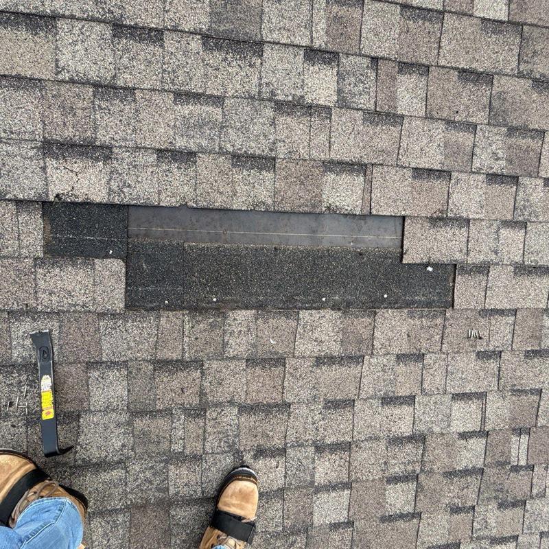 Asphalt shingle roof with removed damaged section