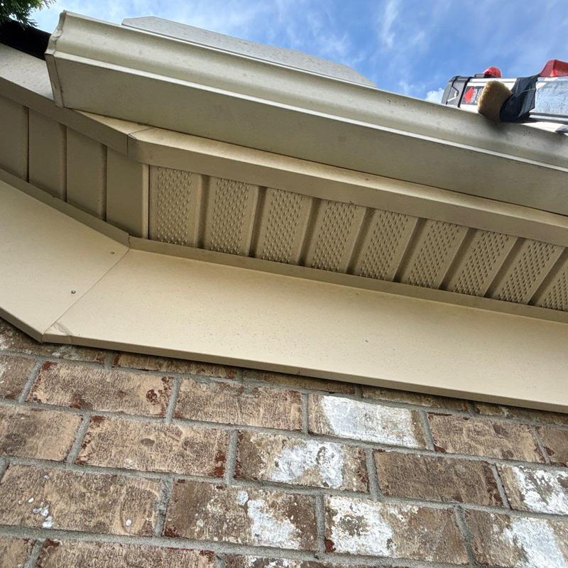 Soffit and gutter system inspection above brick wall