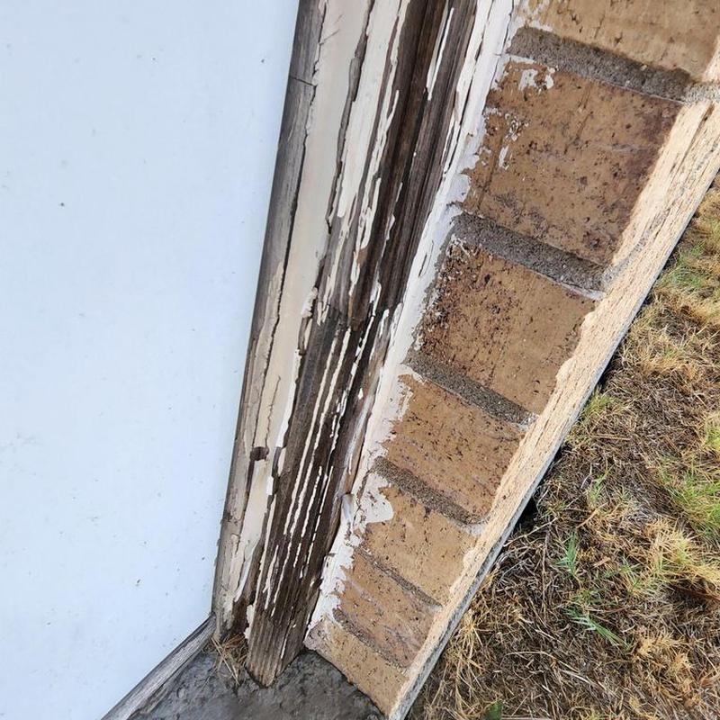 Exterior door wood trim with peeling paint and damage