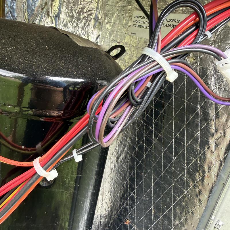HVAC system wiring and compressor housing close-up HVAC system wiring and compressor housing close-up