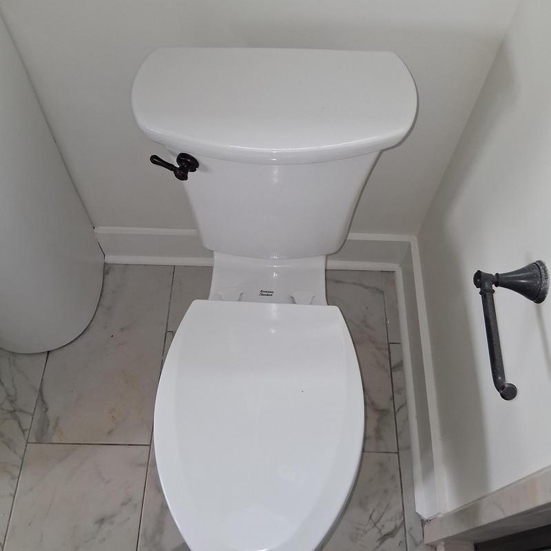 Toilet with closed lid in bathroom corner