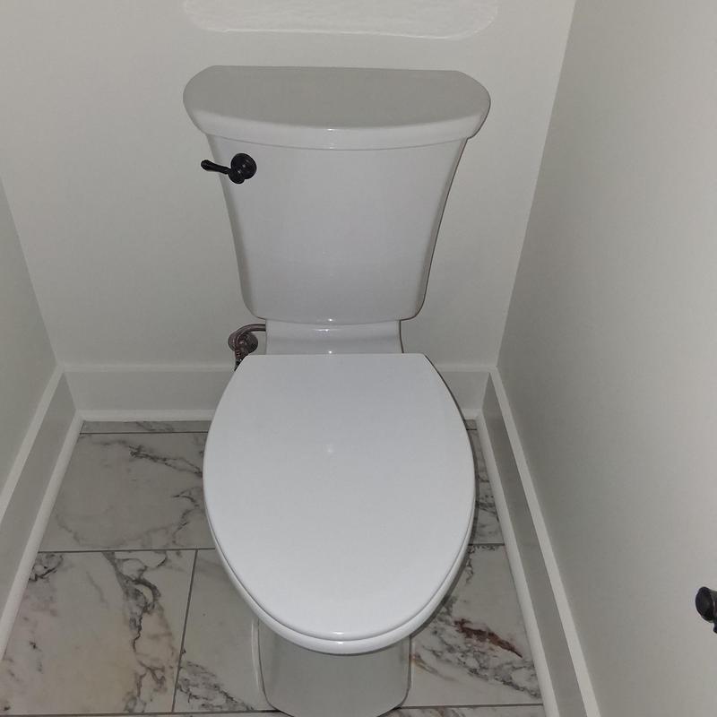 Toilet with closed lid in corner bathroom