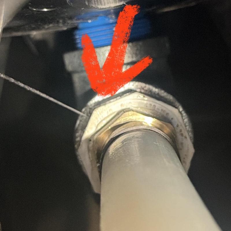 Water well pressure tank fitting with leak indicator