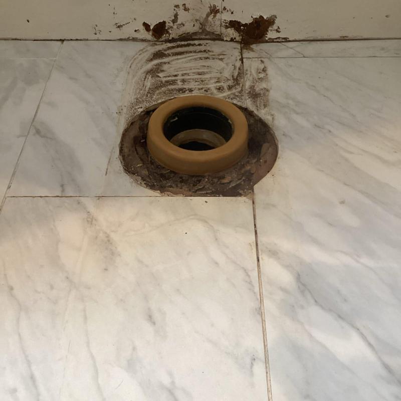 Toilet flange with new wax ring on tile floor