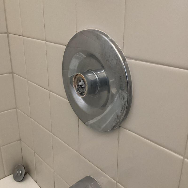 Shower valve with removed cartridge and handle nearby