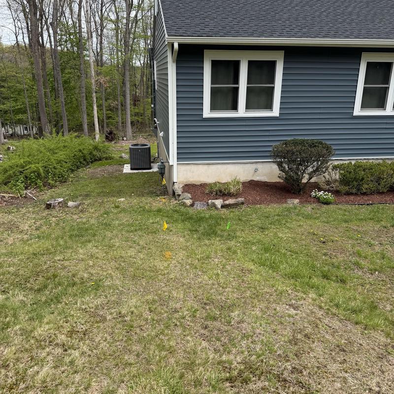 Main sewer line excavation site next to house exterior Main sewer line excavation site next to house exterior