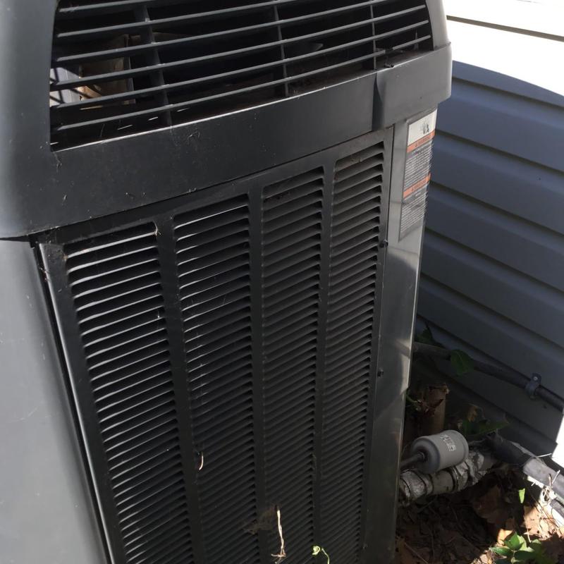 Outdoor air conditioner condenser unit with debris nearby