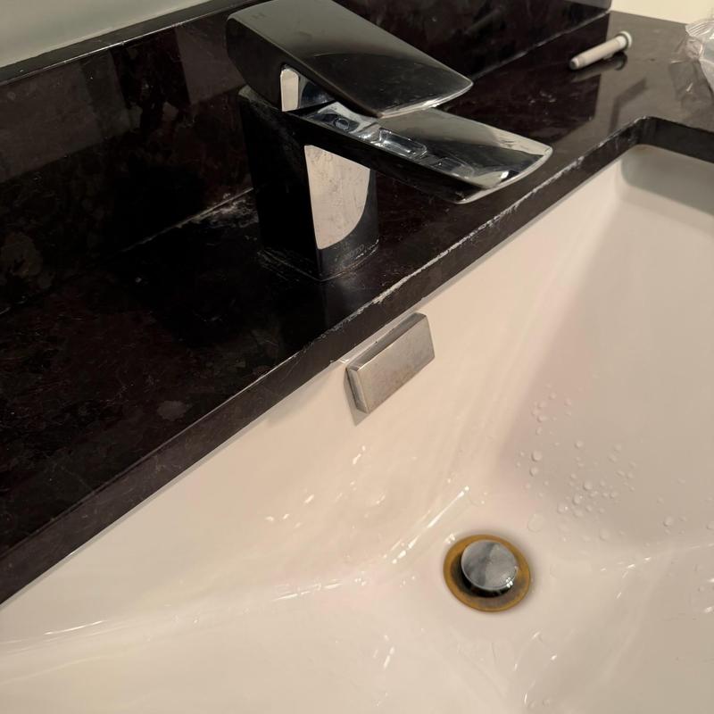 Bathroom faucet and sink with black countertop