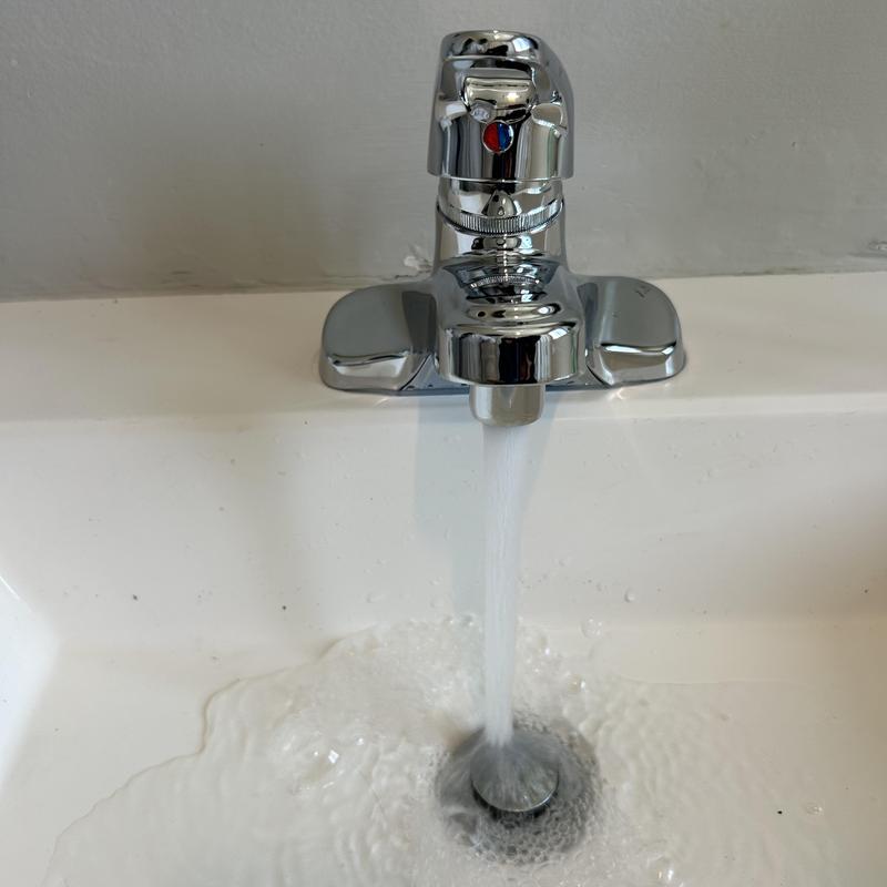 Bathroom faucet with running water and sink drain