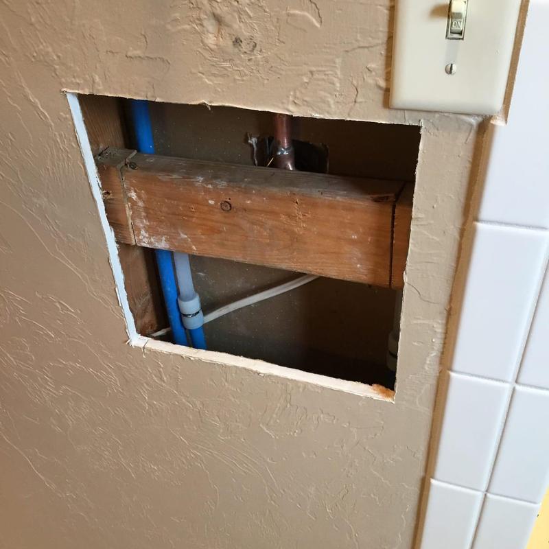 Shower valve wall access with plumbing pipes exposed