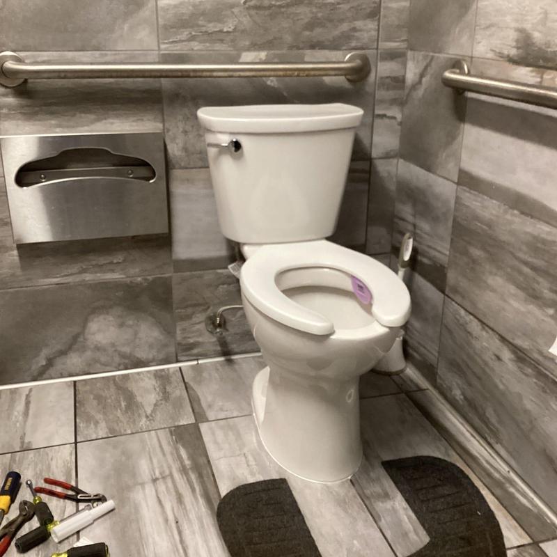 American Standard ADA toilet with open front seat in restroom