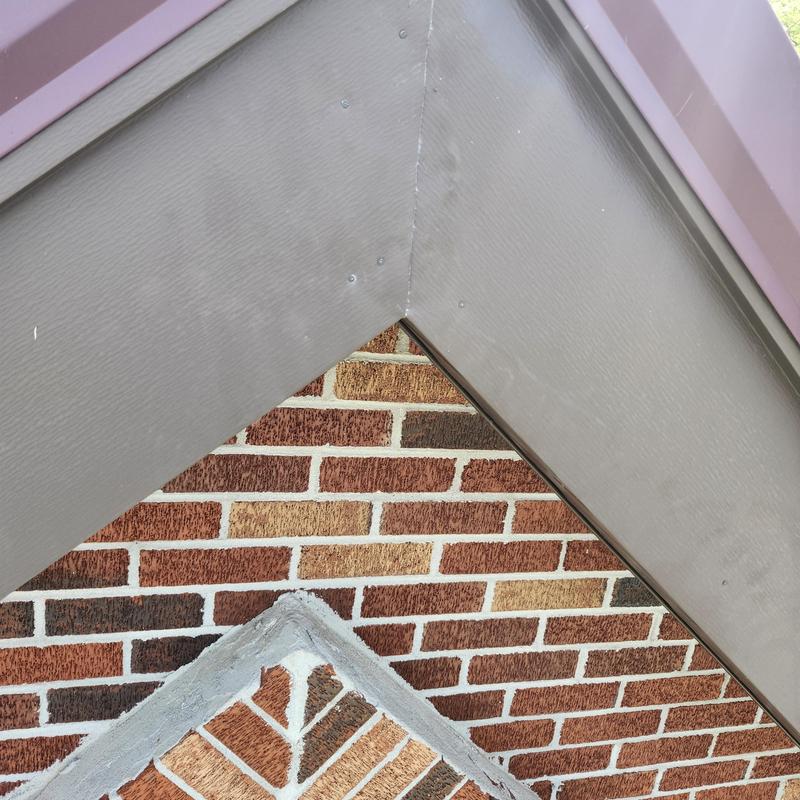 High-pitched roof corner flashing and brick wall junction