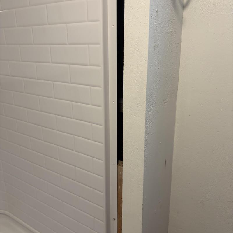 Shower enclosure installation next to drywall corner