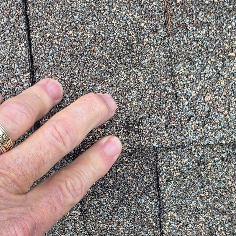 Asphalt roof shingles with hail damage close-up detail