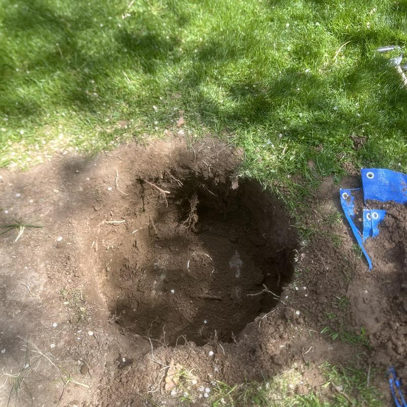 Septic tank excavation hole dug in backyard soil