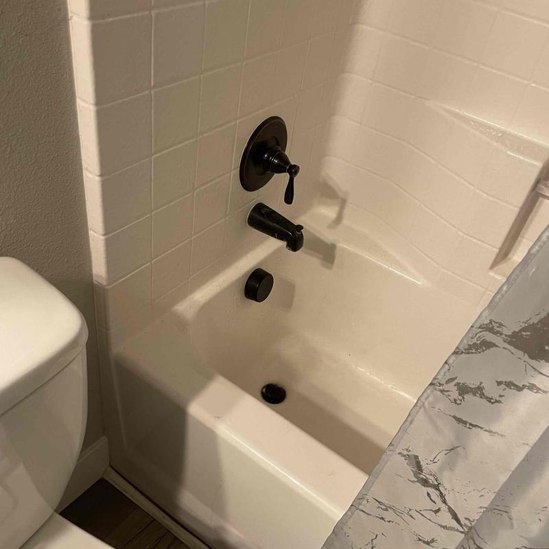 Bathtub faucet and valve with black finish inside bathroom