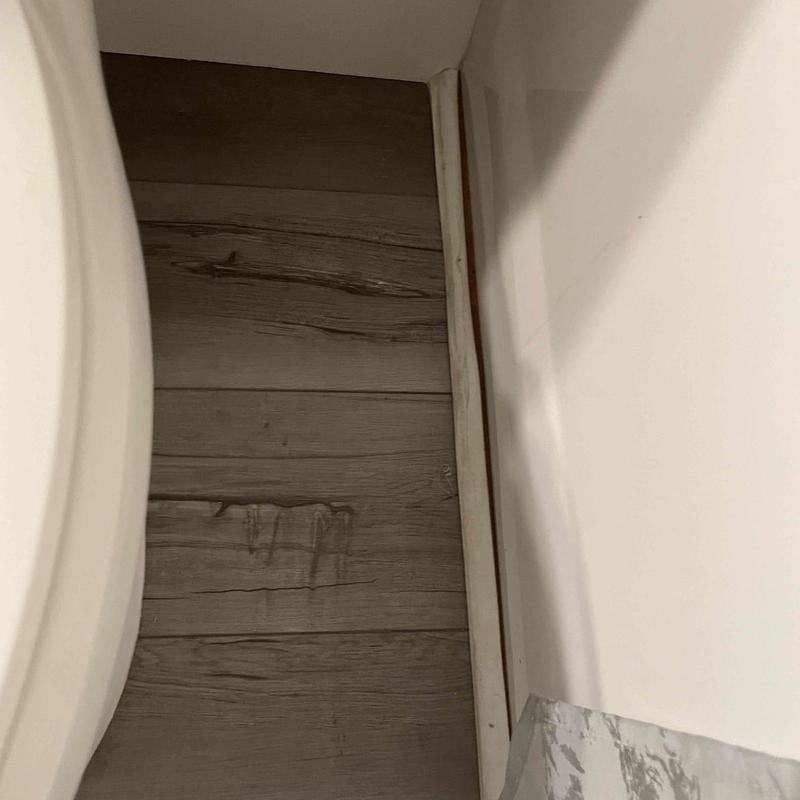 Bathroom baseboard with water damage and stains