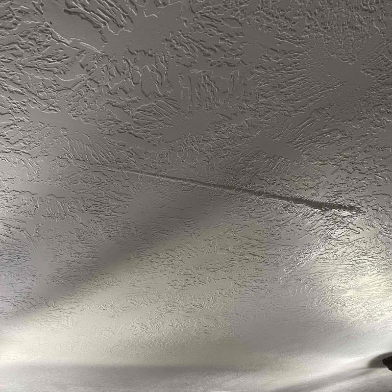 Ceiling drywall with water damage and cracks