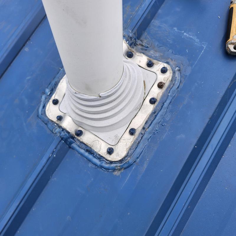 Vent pipe boot on blue metal roof with sealant and screws Vent pipe boot on blue metal roof with sealant and screws