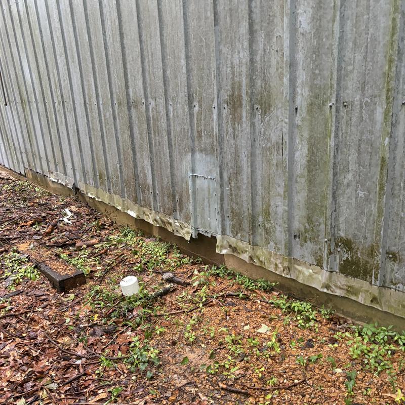 Metal building exterior with damaged lower panels