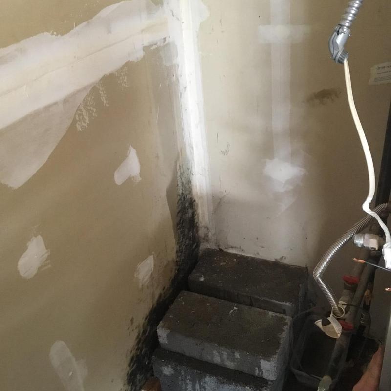Water heater corner with mold and wall repair patches
