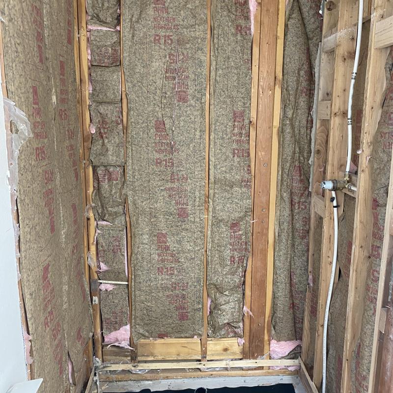 Center drain shower pan with plumbing rough-in and insulation