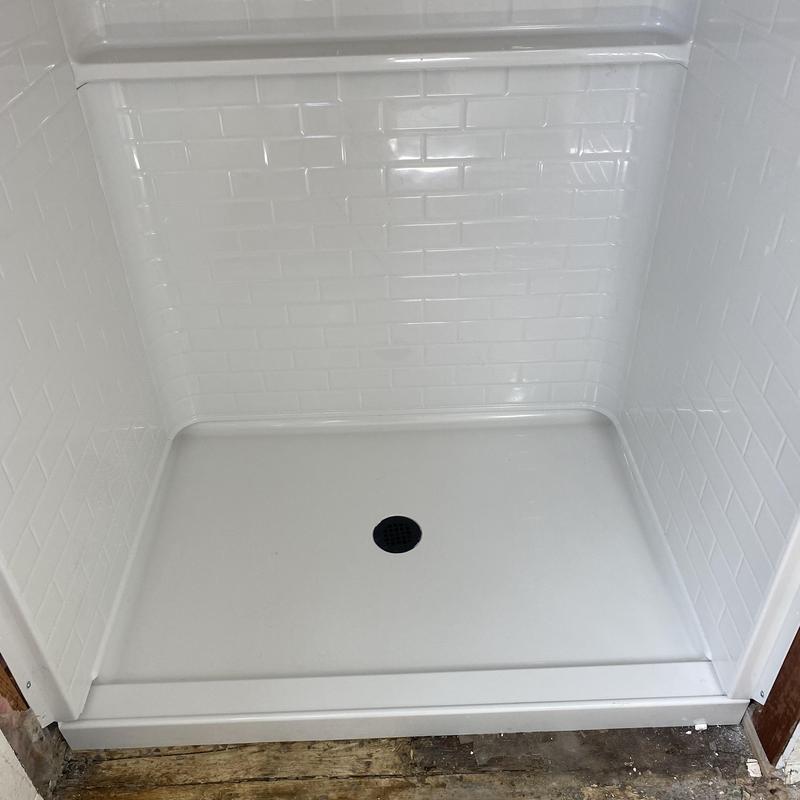 Center drain shower pan with trim and surround installed