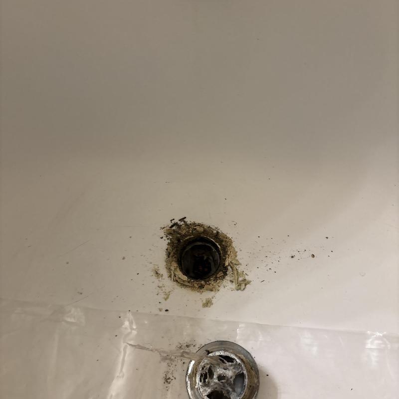 Tub drain opening with removed old stopper and debris Tub drain opening with removed old stopper and debris