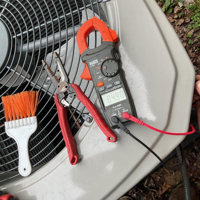 Air conditioner condenser unit with multimeter and wire stripper
