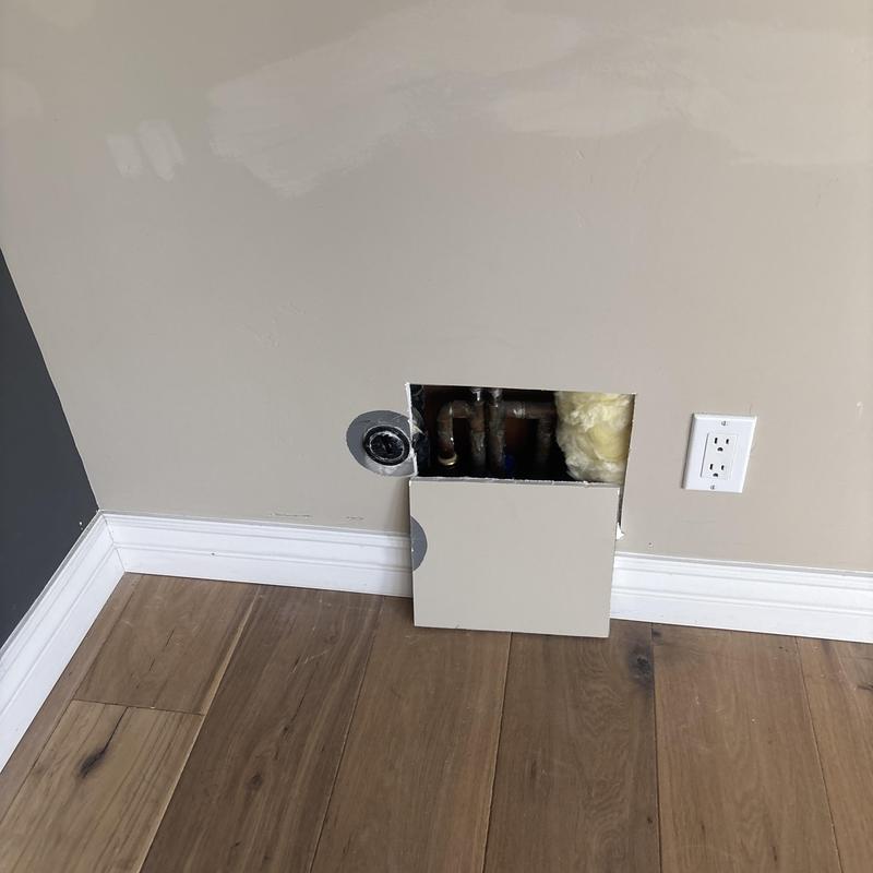 Copper plumbing pipes behind drywall access panel with insulation Copper plumbing pipes behind drywall access panel with insulation