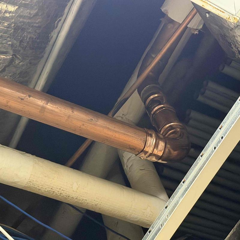 Copper plumbing pipe with repaired elbow joint