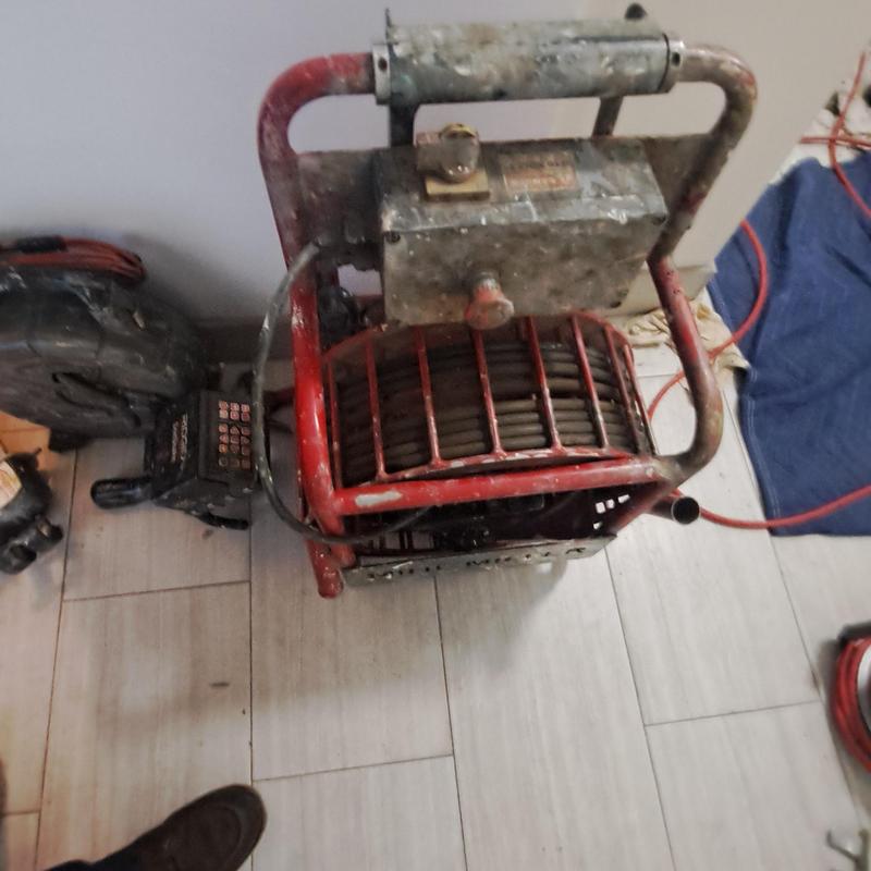 Drain cleaning machine with coiled cable in use