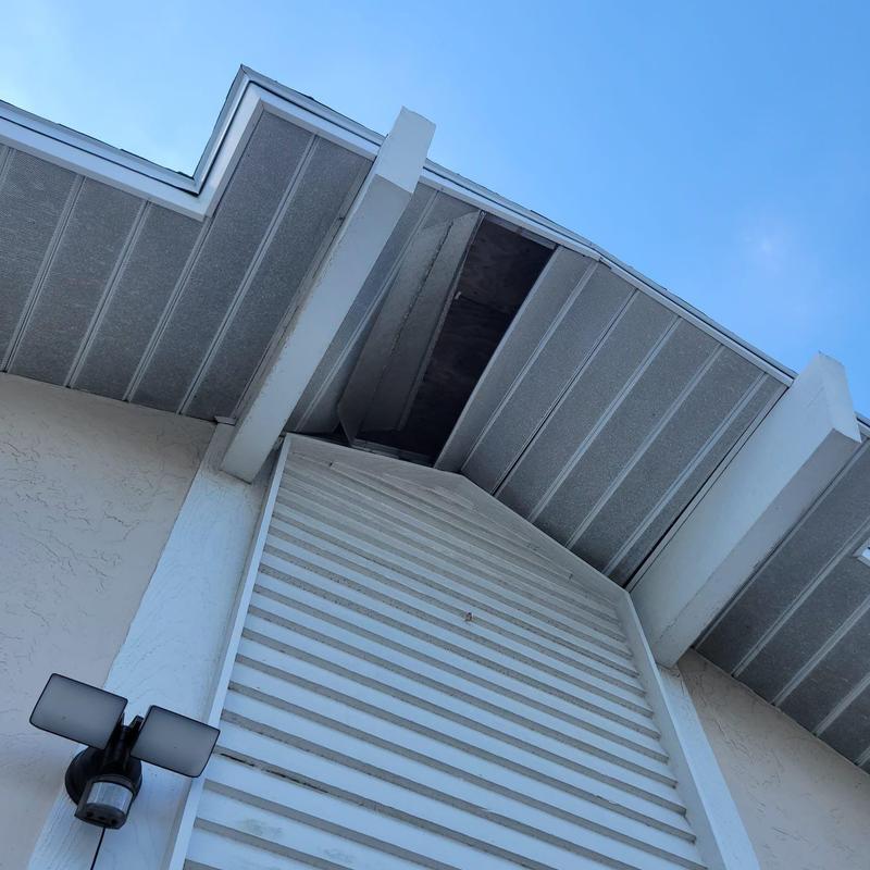 Soffit panel missing above exterior wall with beams