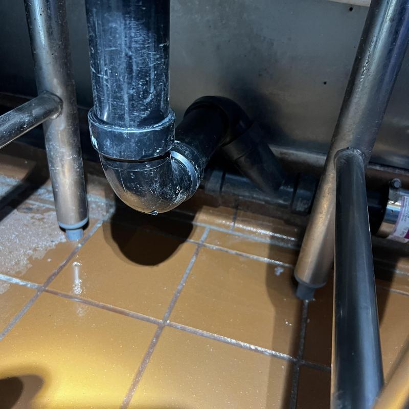 Vegetable sink drain piping under sink floor
