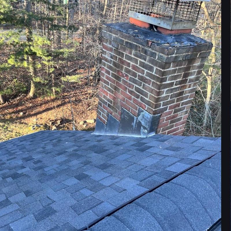 Chimney flashing and black shingle roof installation