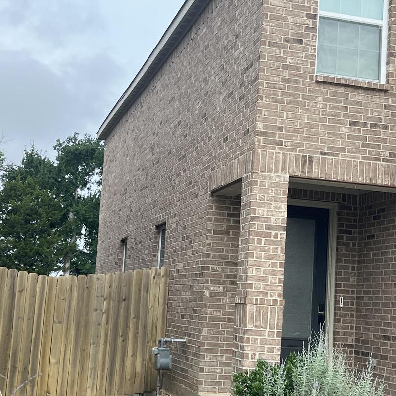 Brick exterior corner and side wall with fence and door