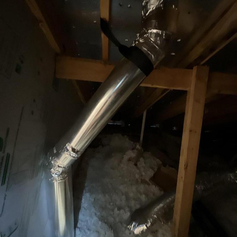 HVAC ductwork installation in attic with insulation