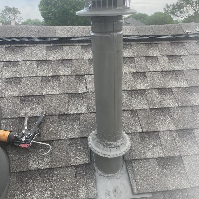 Furnace vent pipe with sealed flashing on shingle roof